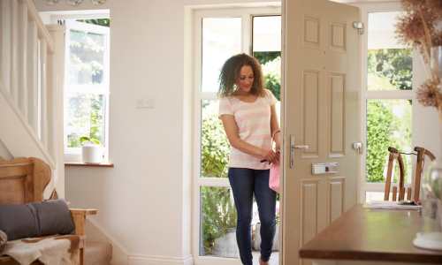 Woman walking through a front door of home